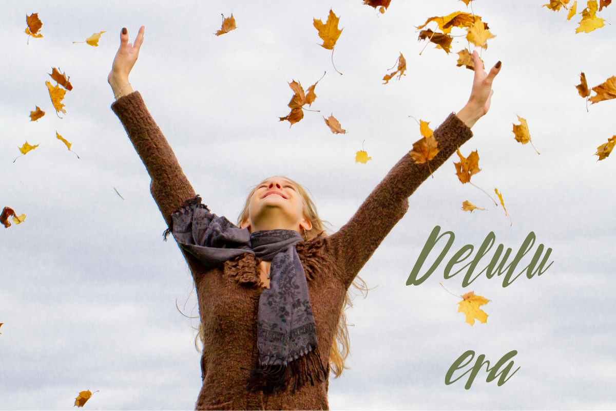 ragazza che alza le braccia al cielo tra le foglie d'autunno